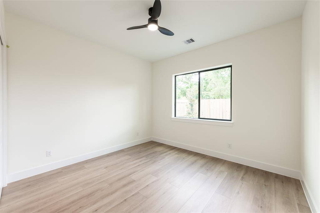 One of the spacious secondary bedrooms, offering ample natural light and versatile space for sleeping, studying, or relaxing.