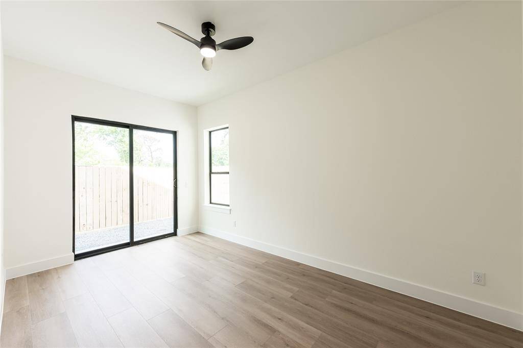 The other generously sized secondary bedroom features sliding glass doors that open directly to the backyard, offering easy outdoor access and plenty of natural light.