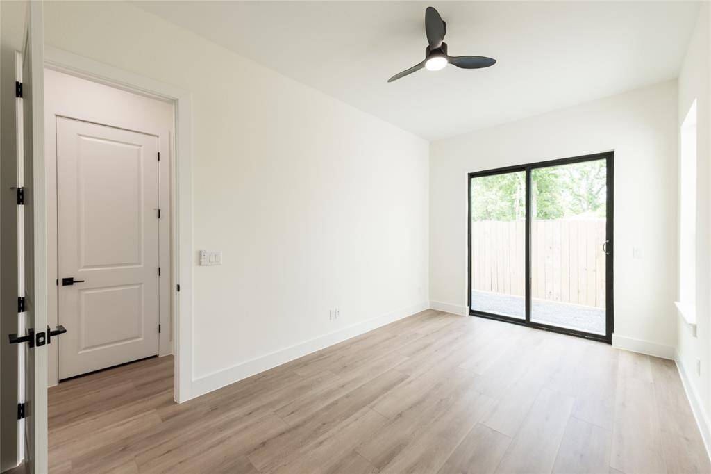 The other generously sized secondary bedroom features sliding glass doors that open directly to the backyard, offering easy outdoor access and plenty of natural light.