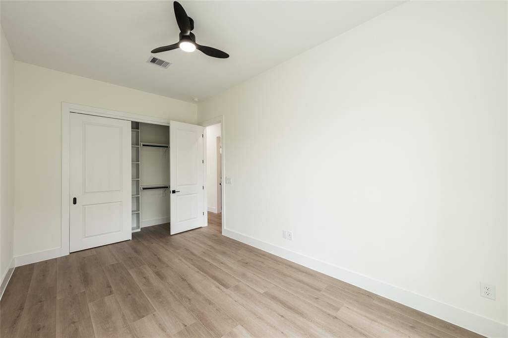 The other generously sized secondary bedroom features sliding glass doors that open directly to the backyard, offering easy outdoor access and plenty of natural light.