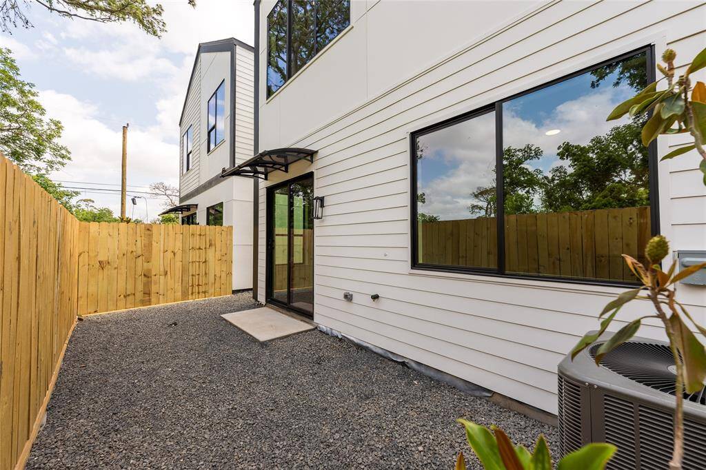 Backyard with a covered awning providing ample shade, complemented by low-maintenance gravel landscaping for easy care and lasting beauty.