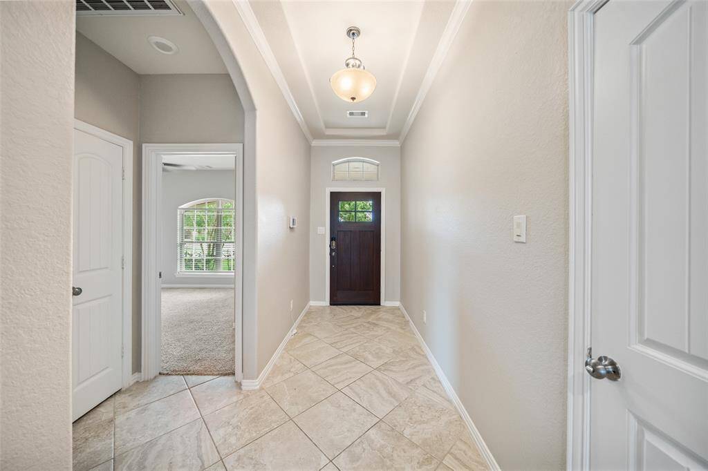 View of the entry with drown molding accenting the tray ceiling