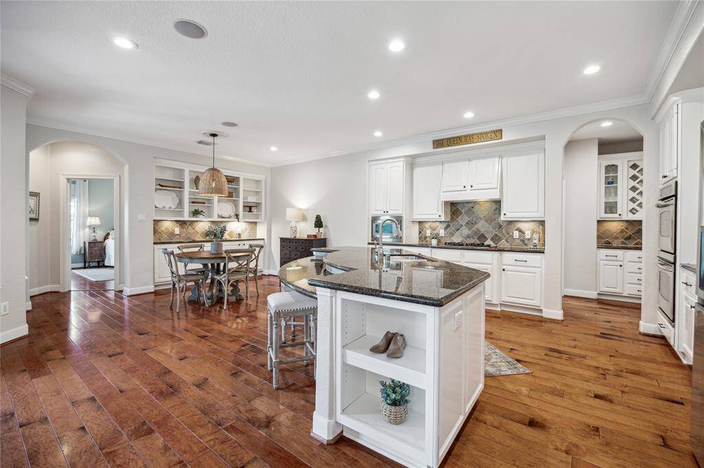 The open kitchen flows effortlessly into the breakfast area and family room, creating a spacious and connected living spaces.