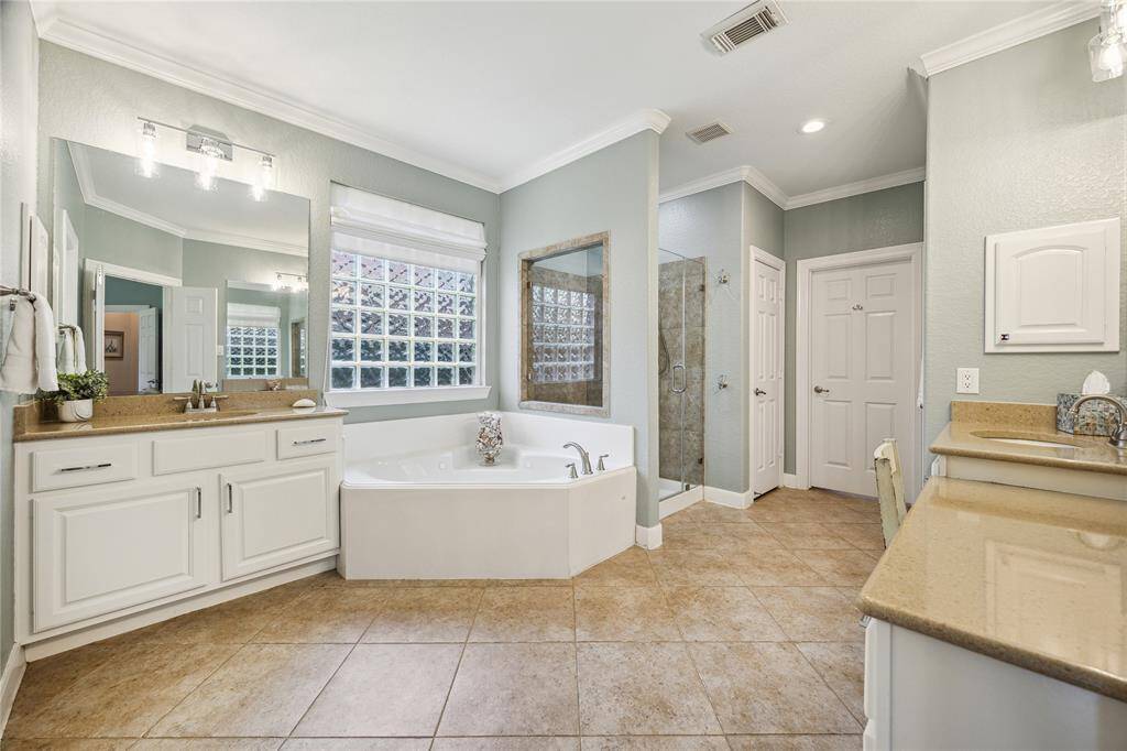 The spa-inspired primary bath features dual vanities, separate tub and frameless shower. Block window allows natural light in while maintaining privacy. The laundry room is conveniently connected to the master bath.