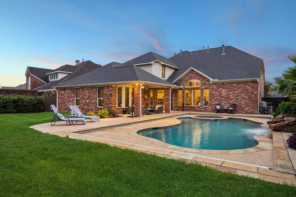 The backyard offers a large grassy area for kids to play and pets to run. Lush landscaping adds extra privacy to the backyard.
