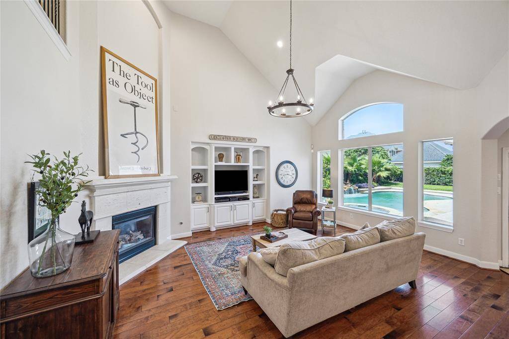 The family room has a cast stone fireplace and built-ins for storage and media equipment.