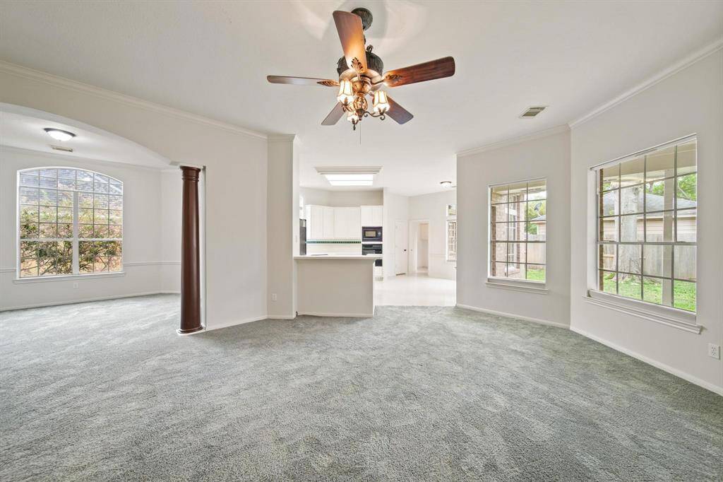 Family room features high ceilings and gorgeous carpet flooring.