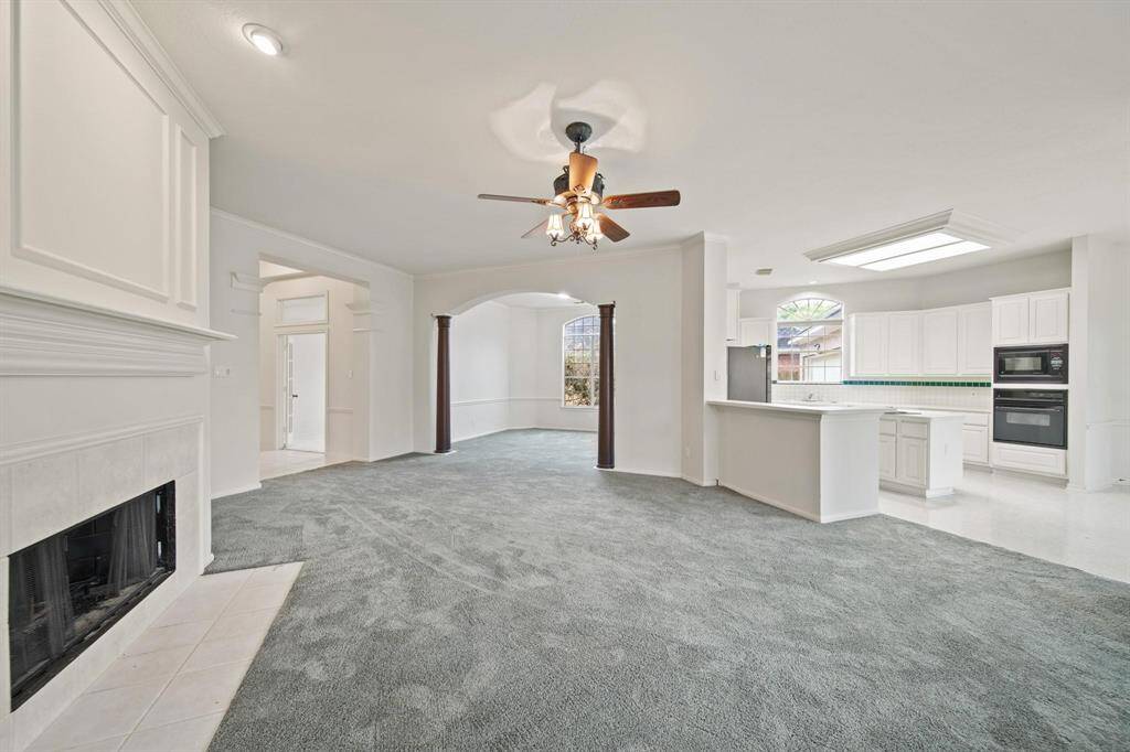 This expansive family room offers a seamless open floor plan that effortlessly connects the living space to the kitchen and dining area.