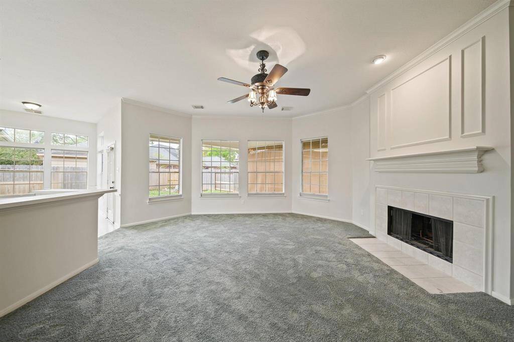 A beautifully designed fireplace adorned tile-surround and a wall of windows that allow gorgeous view of the outside.