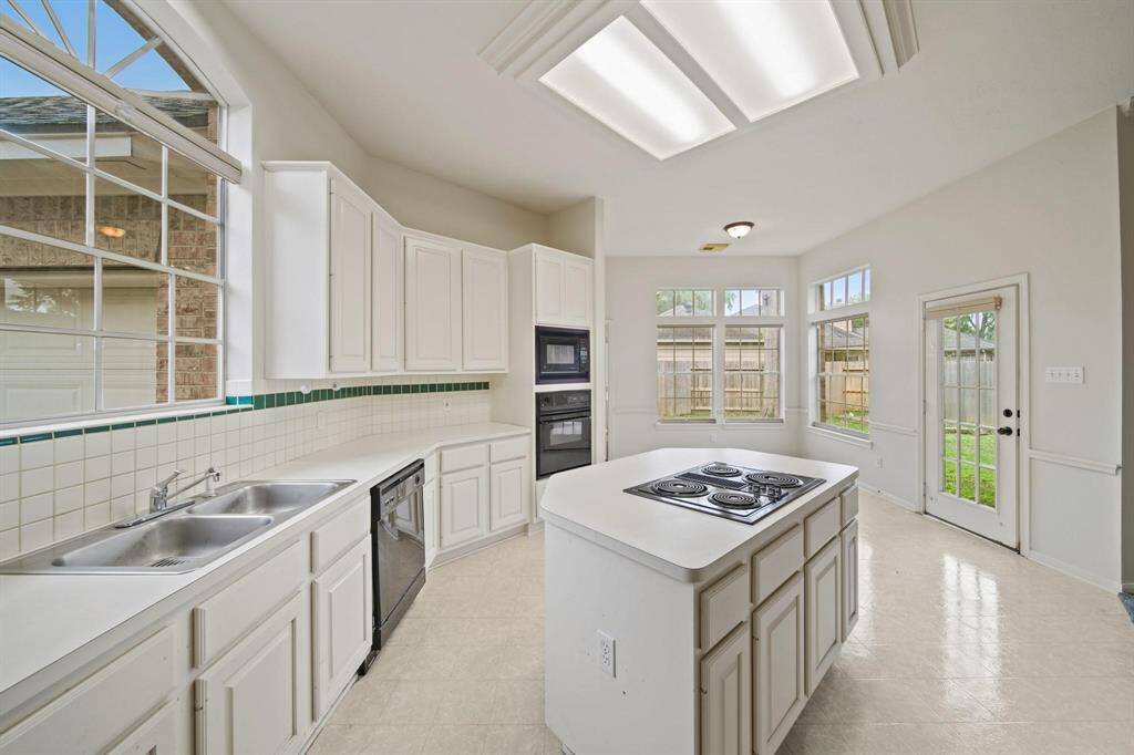The kitchen features a central island with a built-in cooktop, ideal for meal preparation and casual dining.