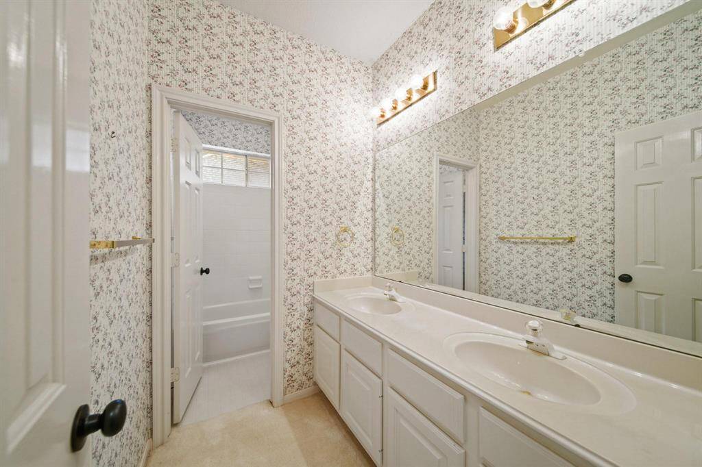 Secondary Bathroom features dual sinks and tons of cabinet spaces.