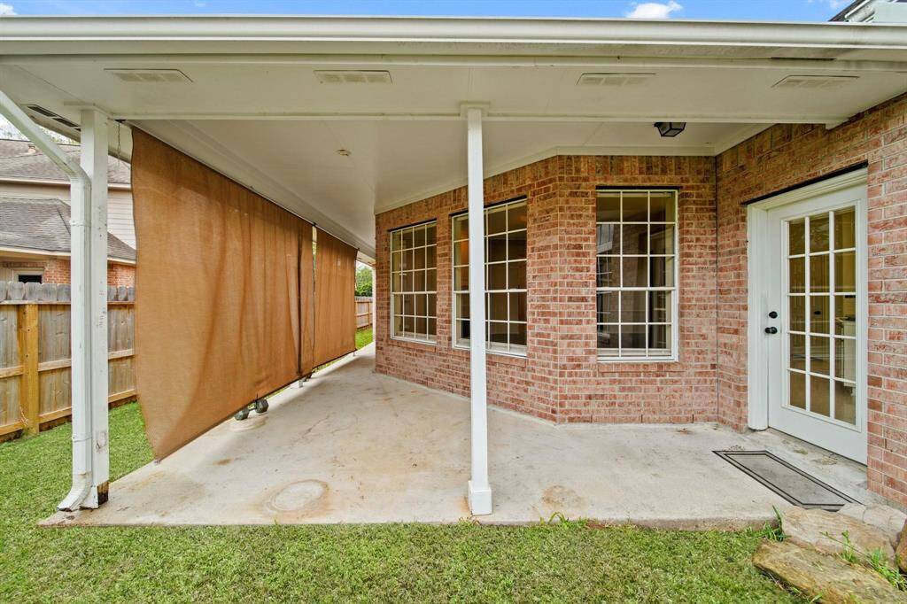 The covered patio provides an ideal spot for entertaining guests or enjoying a peaceful evening outdoors, regardless of the weather.