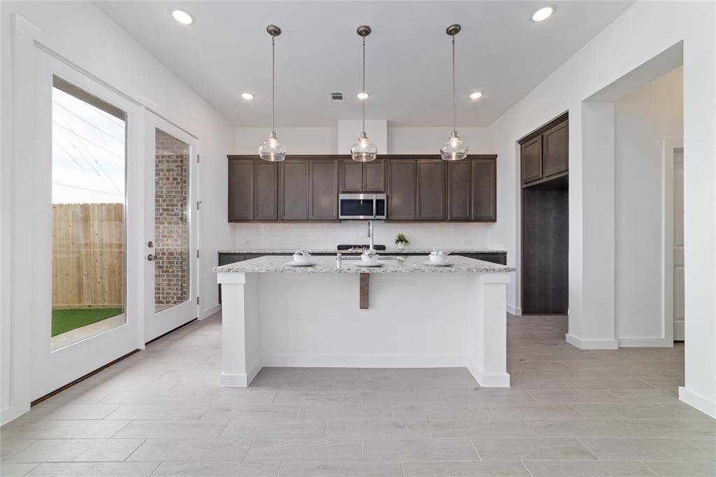 Gorgeous kitchen with granite countertops and elegant pendant lighting