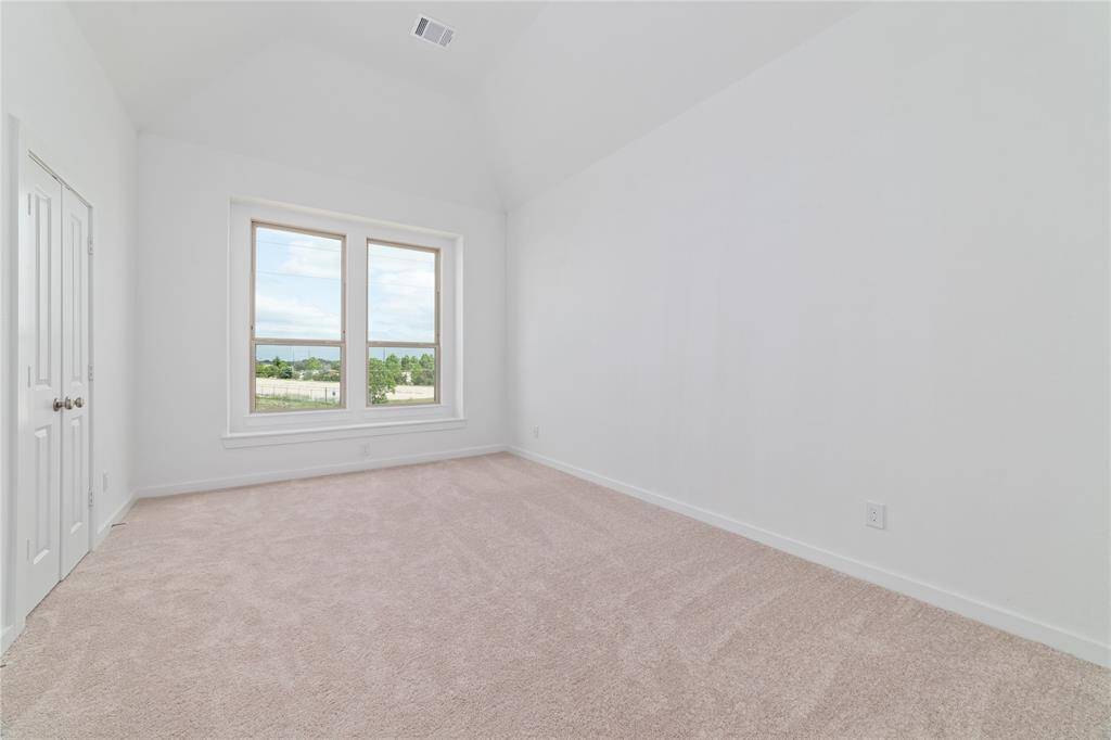 Primary bedroom is spacious with French doors to the bathroom suite and double windows