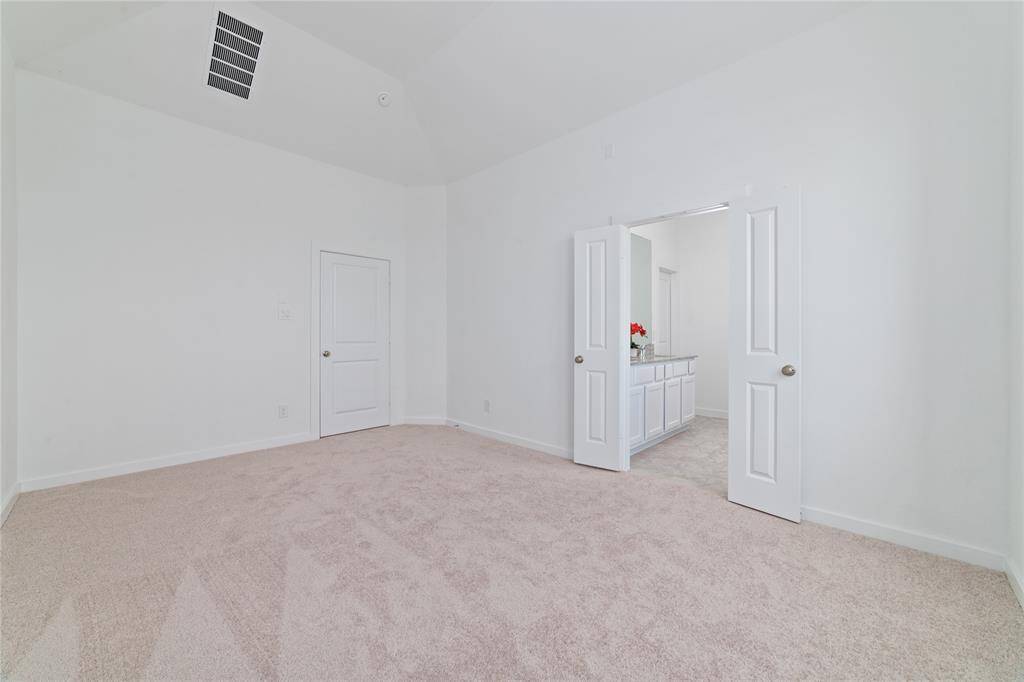 Large freshly carpeted Primary bedroom suite with French doors to the private bathroom