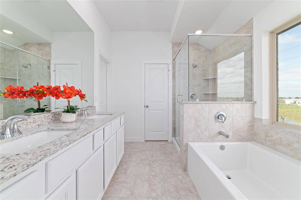 Soaking tub, dual sinks, and granite countertops in the primary bathroom suite