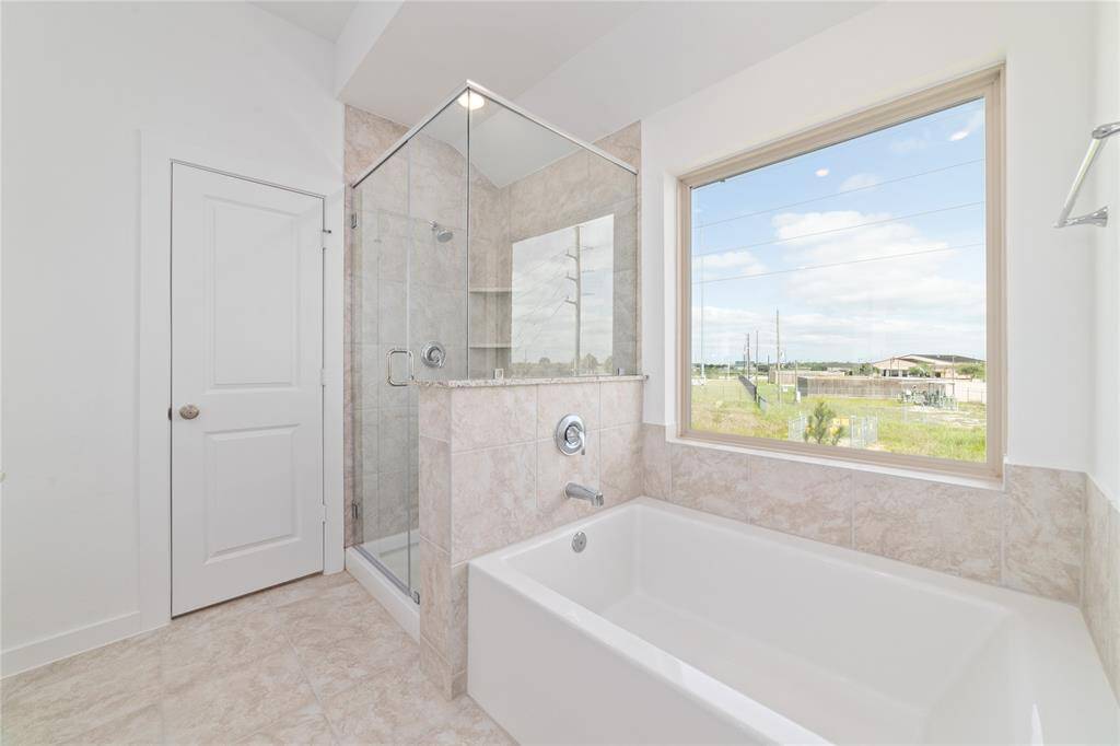 Gorgeous tiled separate stand up shower and soaking tub with plenty of natural light