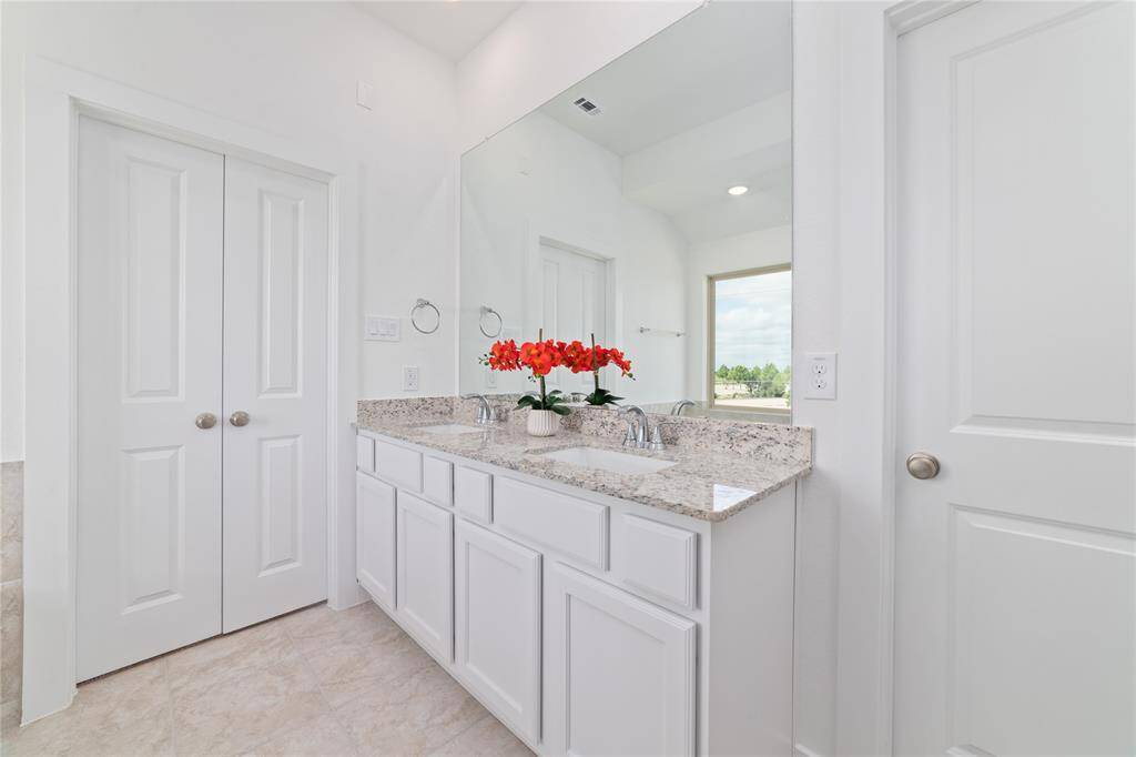 Opposite view of the bathroom suite with granite countertops and dual sinks