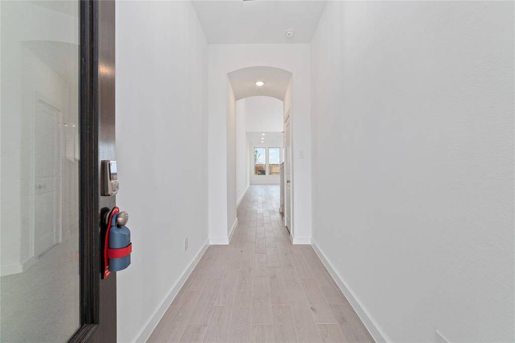 Inviting entryway with high ceilings and light-colored wood-like tile throughout the main floor