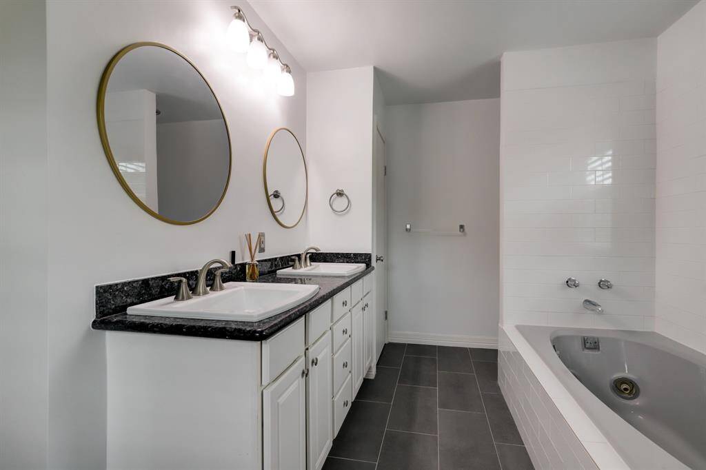 Primary bathroom with double vanity and a jacuzzi tub shown.