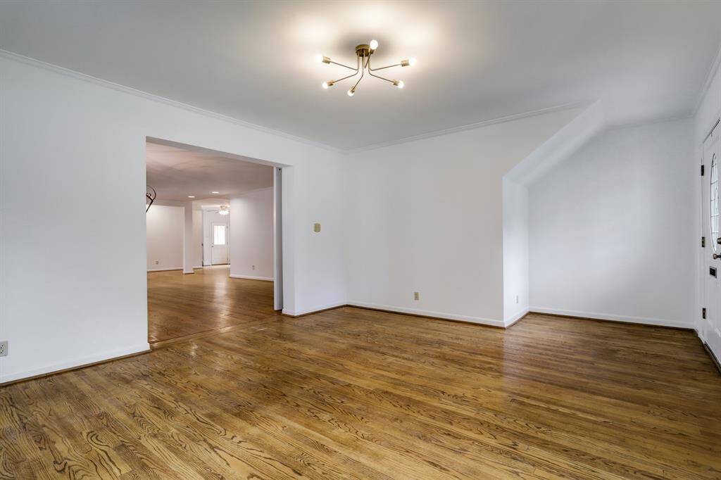 View of living room with entrance to dining room in the distance. Gorgeous hardwood floors throughout the downstairs.