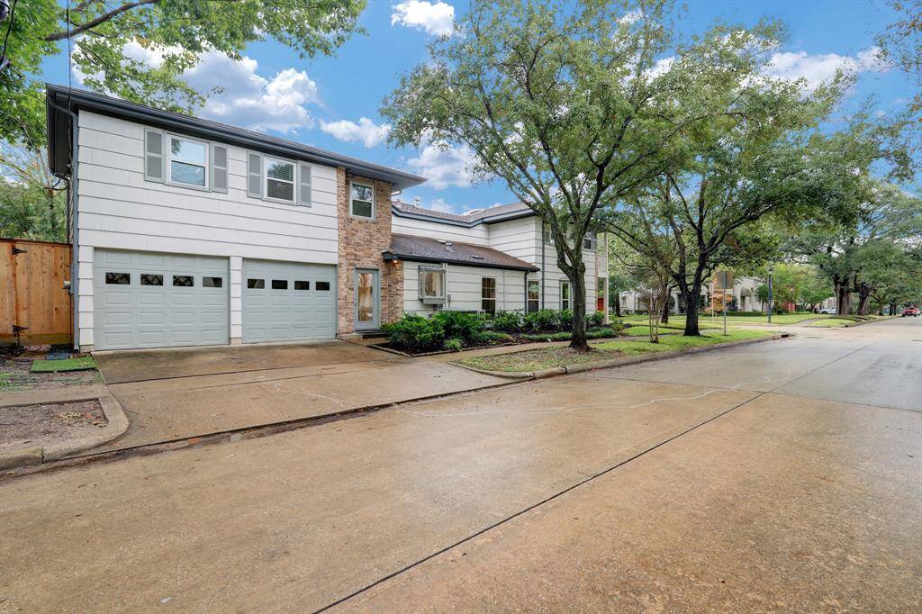 View of the side of the home showing the attached large 2-car garage and the glass side patio door that leads to kitchen and family room.
