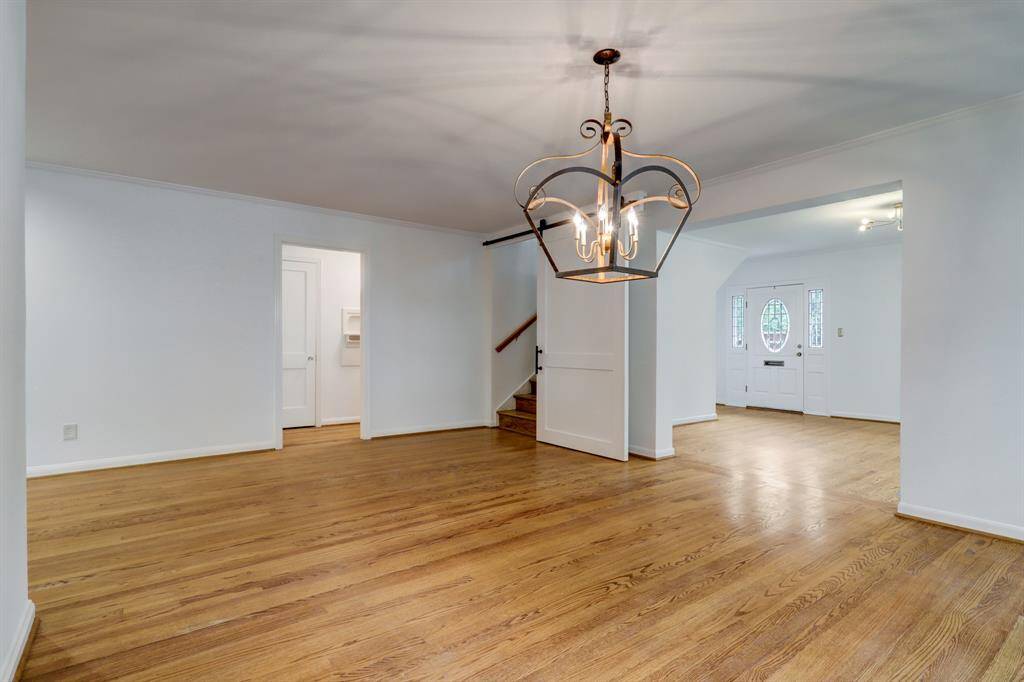 Dining room with view of barn door that leads upstairs to primary suite and hallway door that leads to downstairs bathroom and bedroom.