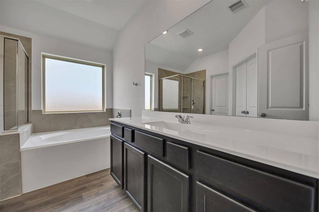 The primary bathroom has a large soaking tub and oversized shower.