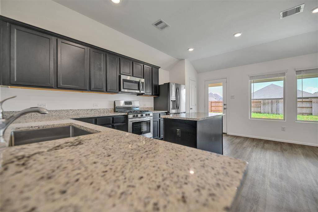 The kitchen has granite countertops, dark cabinets and LOTS of space
