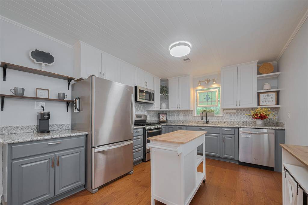 Beautiful kitchen cabinets with new flooring and backsplash.
