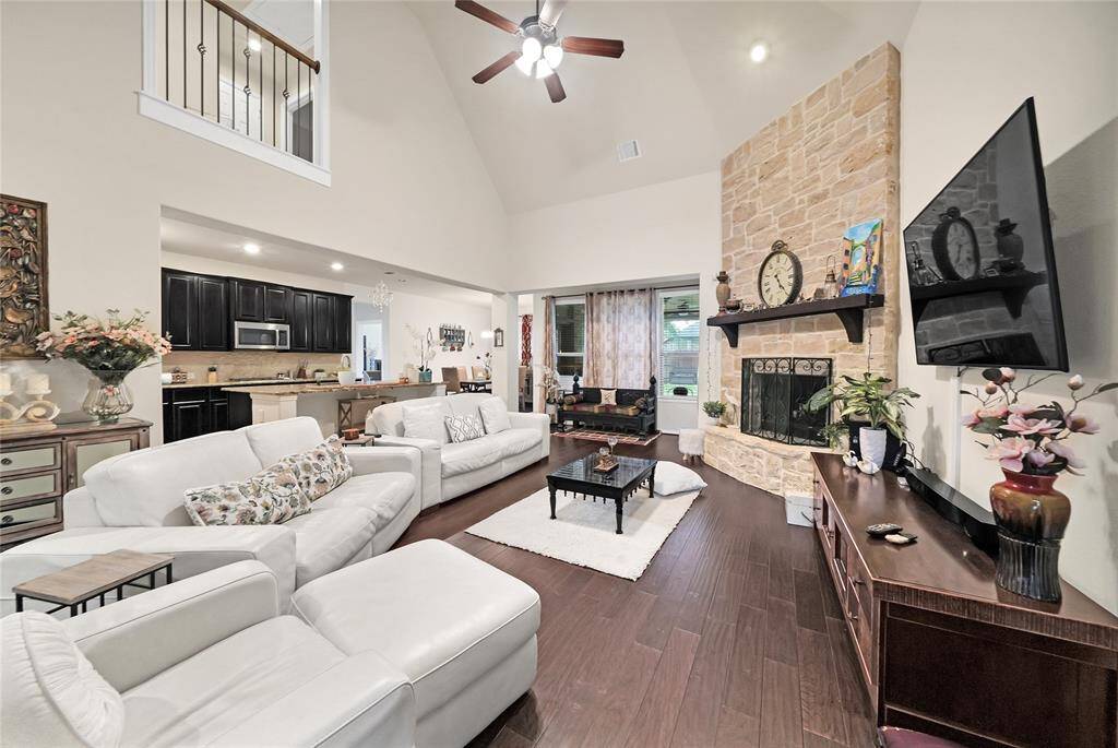 The family room is adjacent to the kitchen and breakfast room and has a gas log fireplace with windows that take in the view of the fabulous backyard.