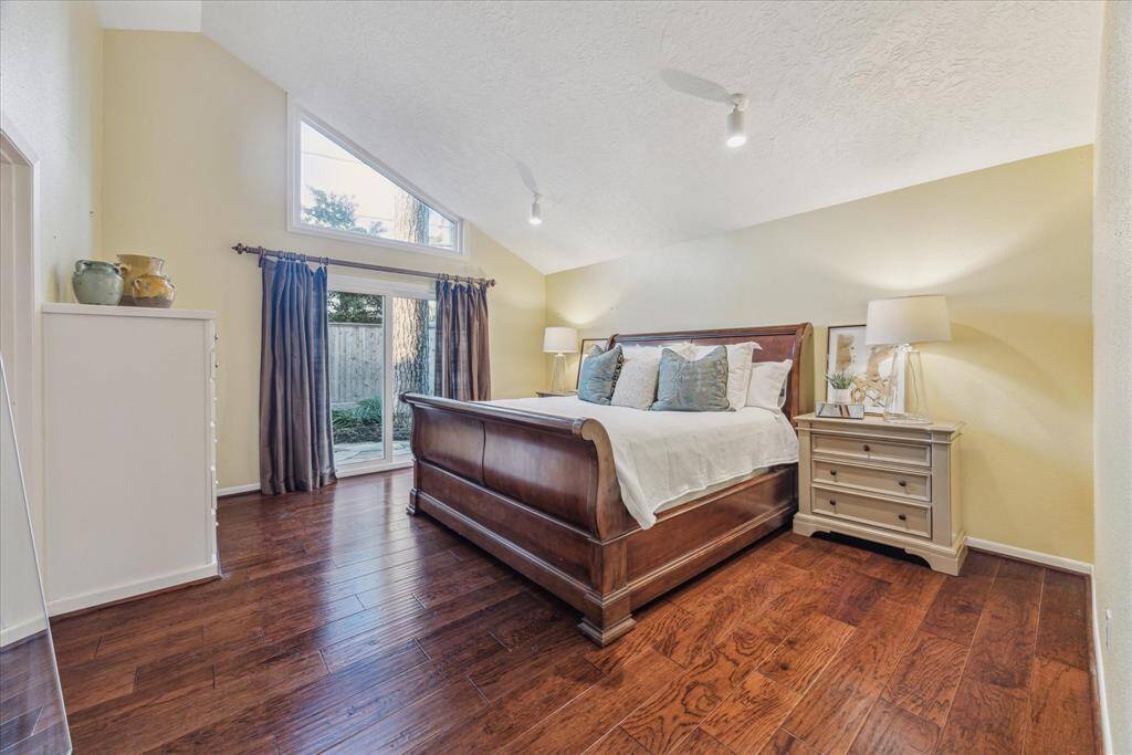 The primary bedroom has high vaulted ceilings and warm wood floors.  Double paned sliders out onto the back flagstone patio.  Nice built-ins expand the closets.