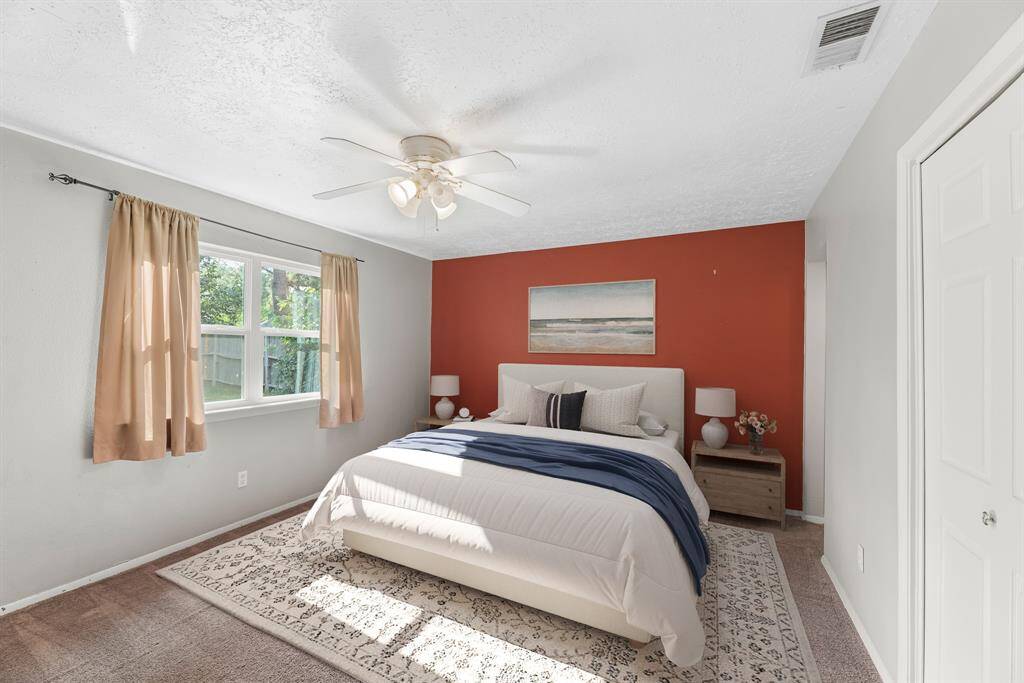 The primary bedroom is generously sized, creating a tranquil and spacious retreat that offers ample room for relaxation. Featuring plush carpet, high ceilings, fresh paint, and large windows that lets in natural lighting throughout the day. *photo is virtually staged*