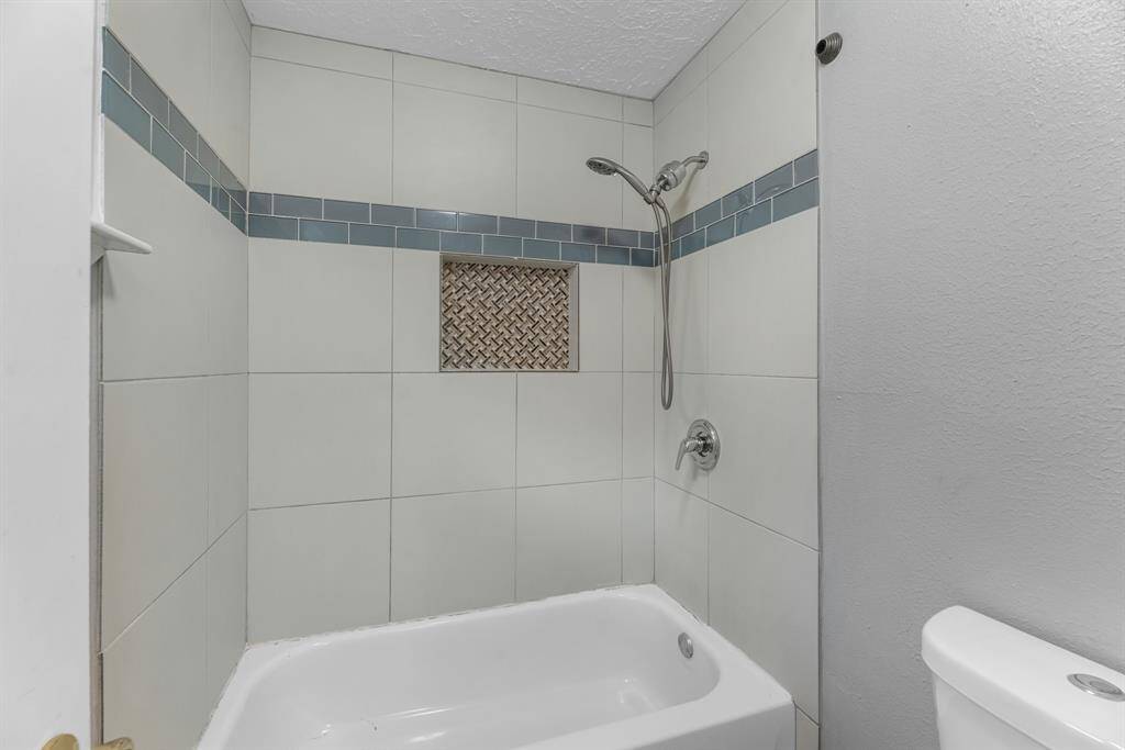 This additional view of your primary bathroom offers a shower/tub combo with custom tile details.