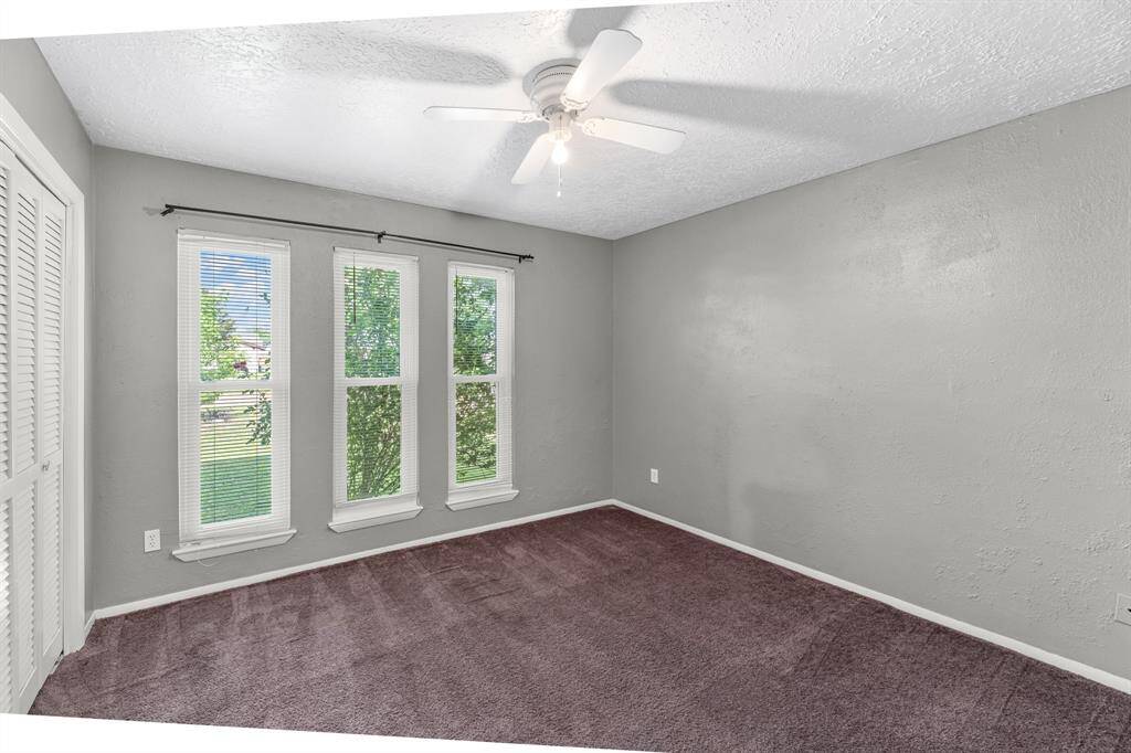 Your secondary bedroom features plush carpet, neutral paint, ceiling fan, and a large windows that lets in plenty of natural lighting.