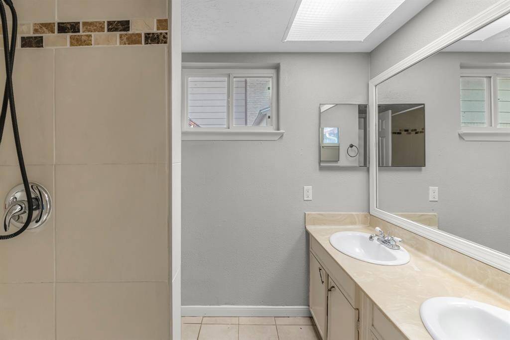 The secondary bath features tile flooring, white cabinetry and light countertops and a shower/tub combo. Perfect for accommodating any visiting family and friends.