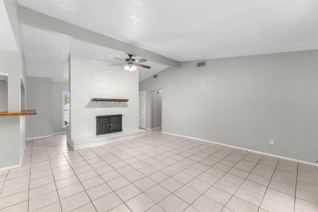 Your family room has ample space to entertain family and friends. This space features tile floors, neutral paint, ceiling fan with lighting, and high ceilings.
