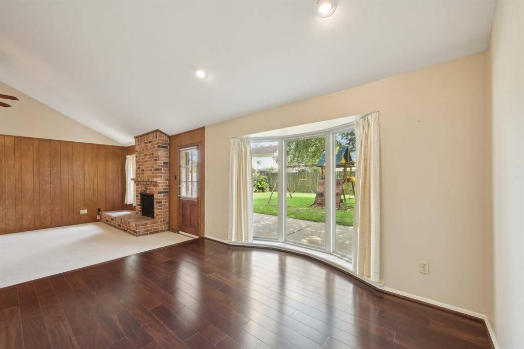 Dining room has wood flooring and a lovely bay window with views of the backyard.