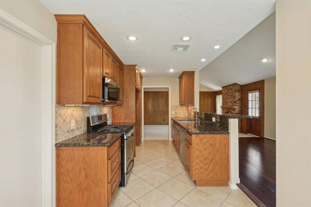 Upgraded cabinets and backsplash with granite counters create a luxurious feel.