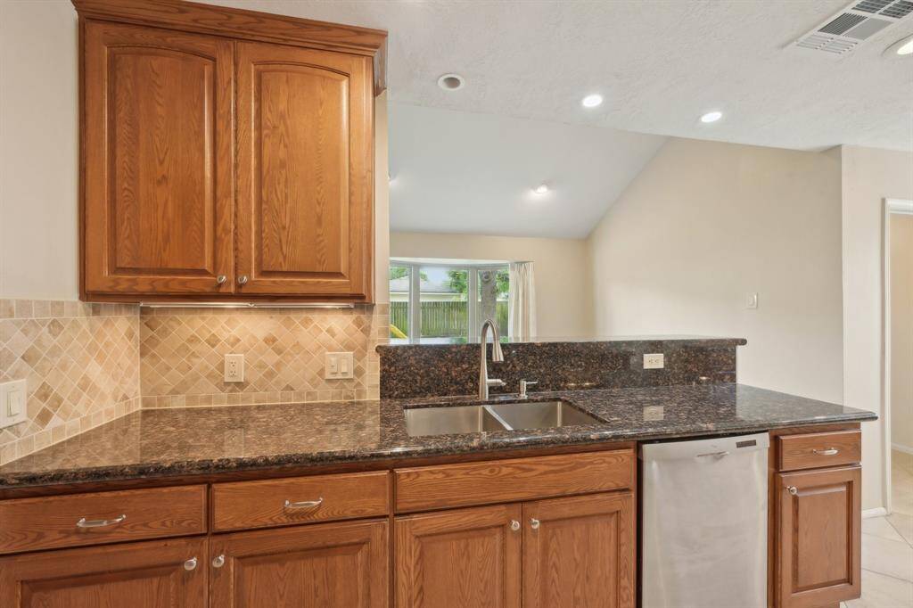 Notice the under-cabinet lighting and custom tile backsplash. The extra deep stainless sink is a great feature.