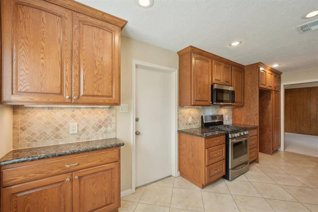 Freestanding gas range is a chefs dream and it has plenty of counter space for prep work. Breakfast nook features extra cabinets and counter space. Door leads to garage.