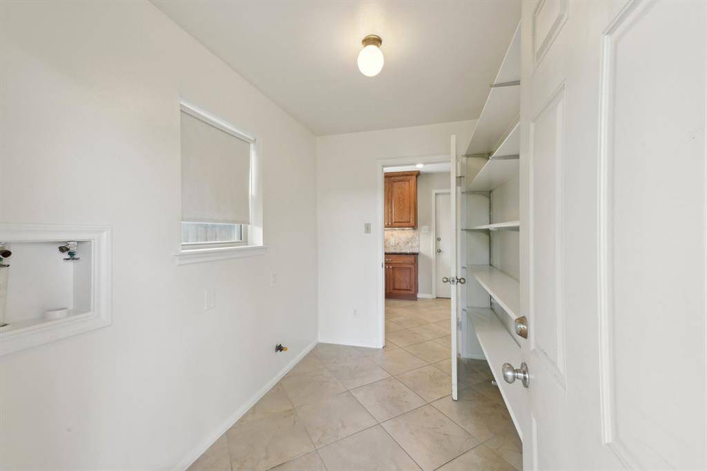 Laundry room has a wall of built-in shelving for the ultimate pantry storage.