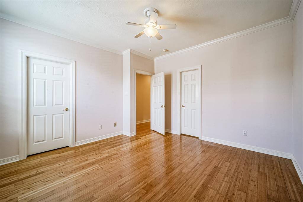 Bright, bedroom with hardwood floors, neutral walls, and large windows for natural light. Ideal for a home office or small bedroom.