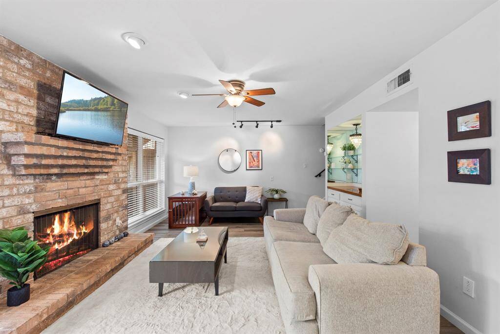 Cozy up in a warm and inviting living space, anchored by a charming brick fireplace, expansive window light, ideal for comfy gatherings.