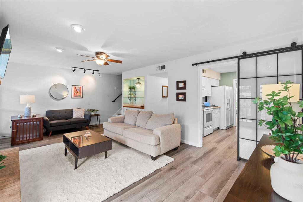 Family room with access to the kitchen, notice the modern glass barn door that provide access to kitchen. Also notice the dry bar with glass shelving, this area is perfect for the family of entertainment.