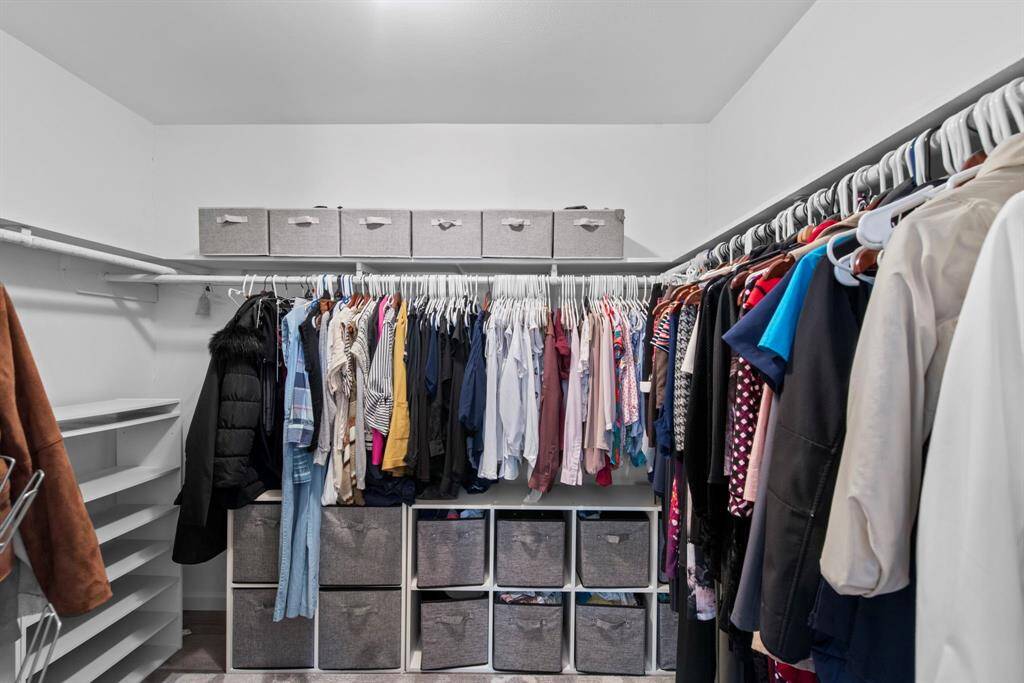 A generous walk-in closet with wrap-around hanging space, cubby storage, and shelving—designed to keep everything neat and organized.