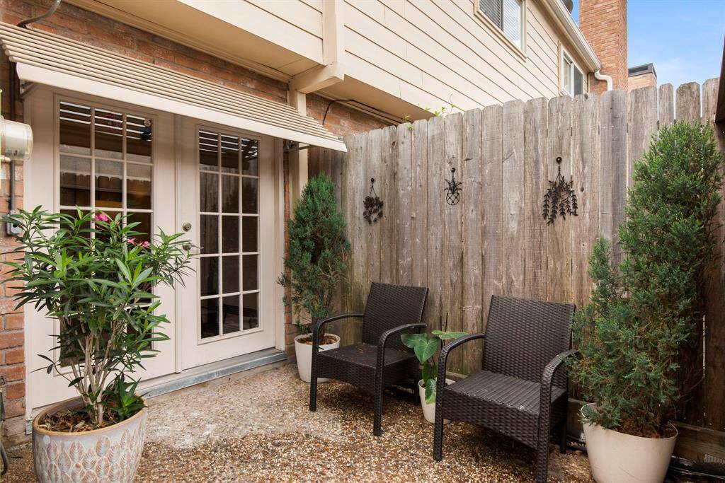 A stylish outdoor seating area under the pergola, surrounded by greenery for a private, tranquil escape.
