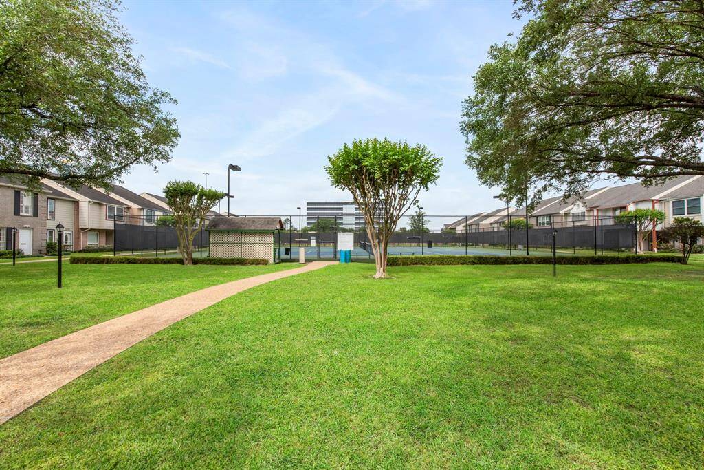 A lush central lawn and winding paths offer room to roam, play, or picnic under the trees.
