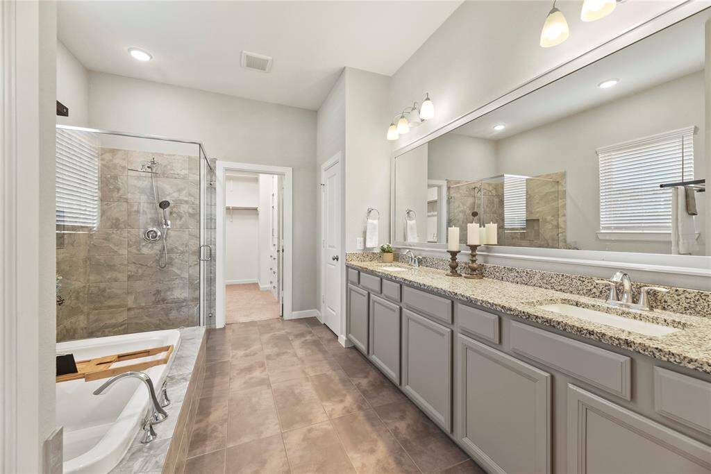 This is truly even more beautiful in person! The impressive vanity space has plenty of storage, double sinks, a beautiful soaking tub and framed shower.