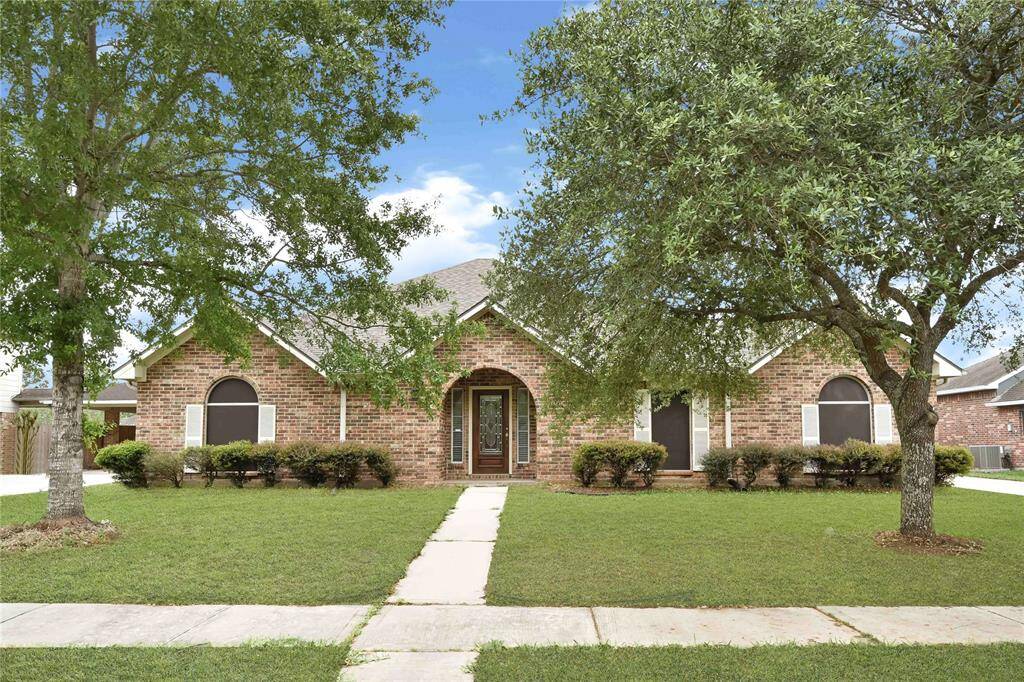 Welcome home to 11108 Dawson Road with a welcoming front path, lush lawn, and mature trees. Features arched windows and a central entrance, creating a classic and inviting curb appeal.